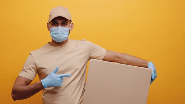 Delivery Man with Face Mask and Gloves Holding Package and Pointing Finger Into It