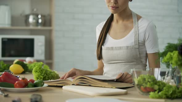 Asian Woman Reading Cooking Book and Choosing Salad Recipe Healthy Food