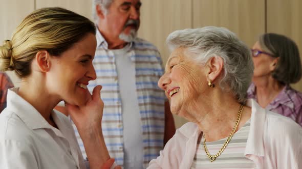 Happy female doctor and senior woman looking face to face 4k