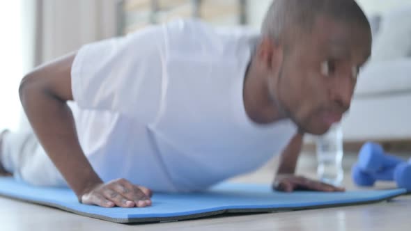 Close Up of African Man Doing Pushups on Yoga Mat at Home