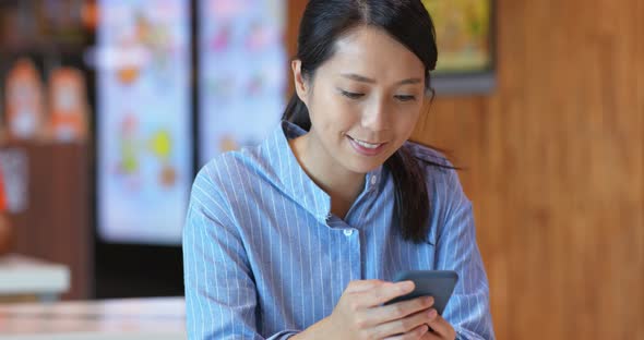 Woman use of mobile phone inside shopping center