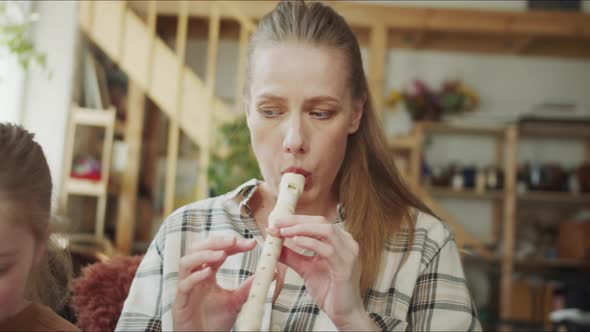 Mom Plays the Flute and Her Daughter Shows Her Notes on the Phone