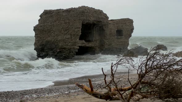 Big stormy waves breaking against abandoned seaside fortification building ruins at Karosta Northern