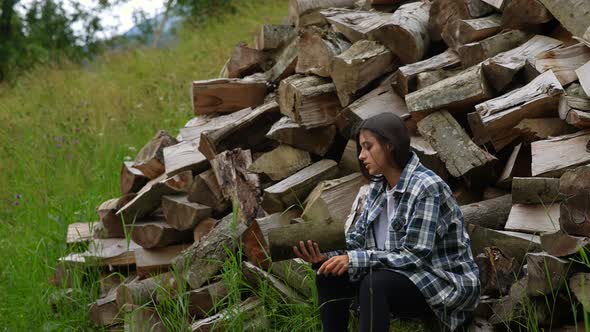 Woman in the Forest Near the Pole of Chopped Wood