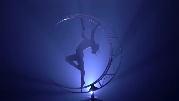 Girl Performs Various Hooks in a Dark Room on a Device in the Form of a Spinning Moon