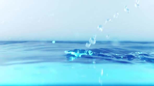 The clean water surface in slow motion fills the screen with water splashing shop the water drop and