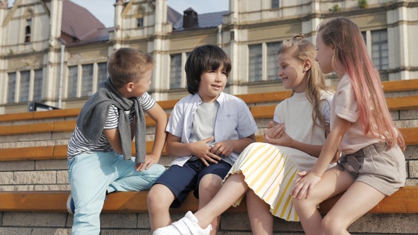 Four children sitting together smiling and talking.