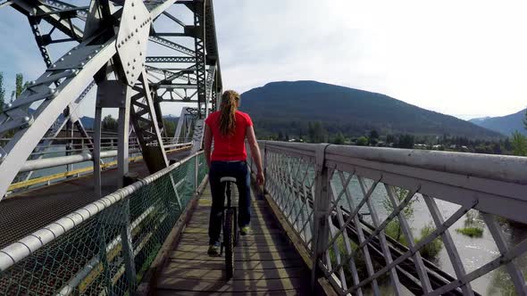 Woman riding unicycle on the bridge 4k