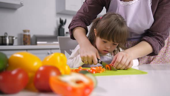 Child with Special Needs Cutting Pepper on Board