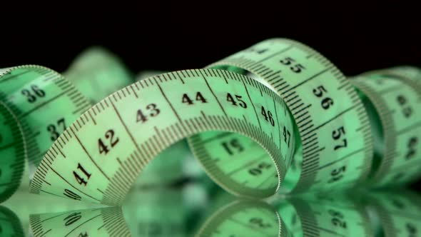 Green Measure Tape, on Black, Rotation, Reflection, Close Up