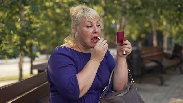 Plump Woman Paints Her Lips on the Street
