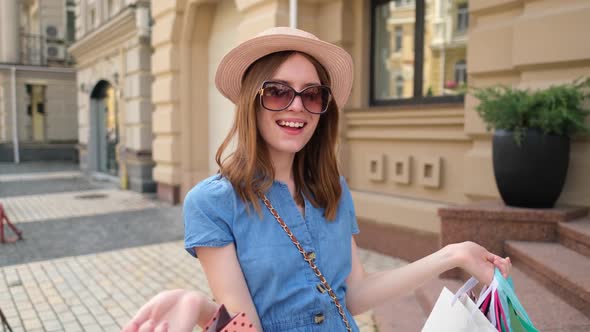 Young Woman with Shopping Bags Walking in a City at Summer Day