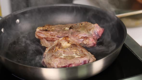 Chef frying meat in a pan