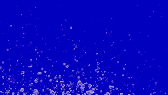 Multiple Drops of Water Fly Up and Spray in Different Directions on Blue Background