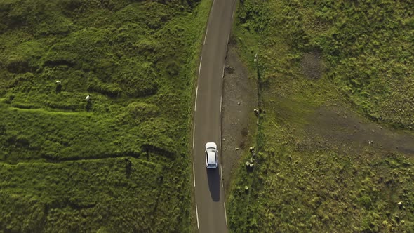 Top Aerial View of a Car Driving During Sunset