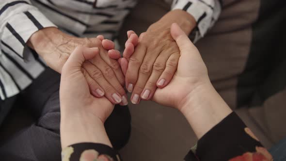 Close Up Mature Elderly Woman Holding Hands of Grown Up Daughter, Showing Love and Care.