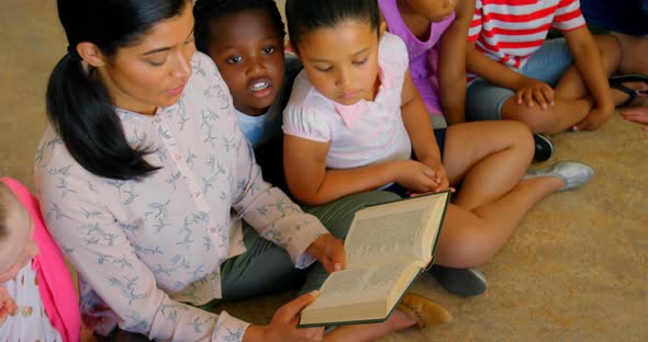 Asian female teacher teaching schoolkids in school library 4k