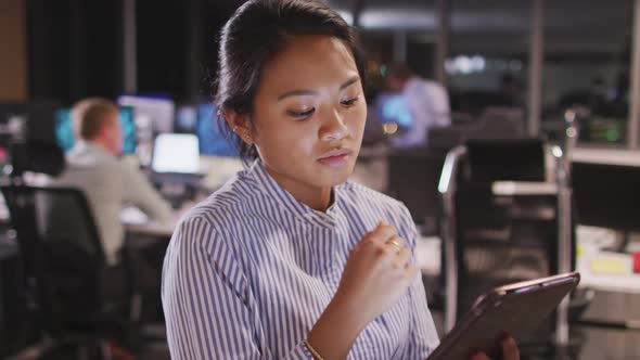 Professional businesswoman using a digital tablet while sitting in modern office in slow motion