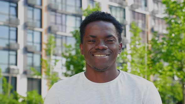 Close Up Smiling Afroamerican Man Looks Camera on Background Modern Building