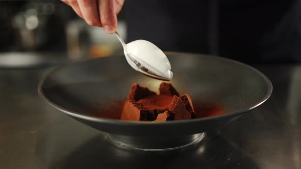 Chocolate brownie dessert is decorated with ice cream in a professional restaurant kitchen