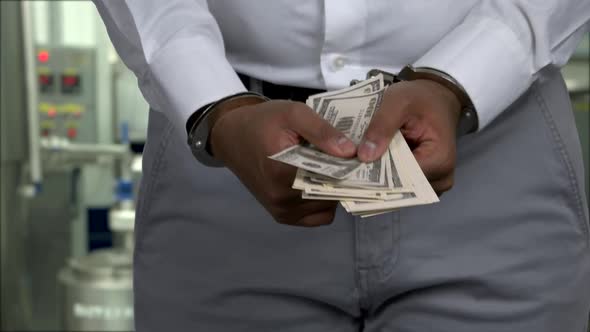 Close Up Handcuffed Businessman Holding Hundred Dollar Bills