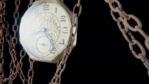 Antique Gold Pocket Watch Hanging From a Rough Rusty Chain