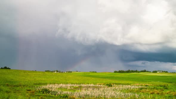 Rural landscape, rain clouds and rainbow