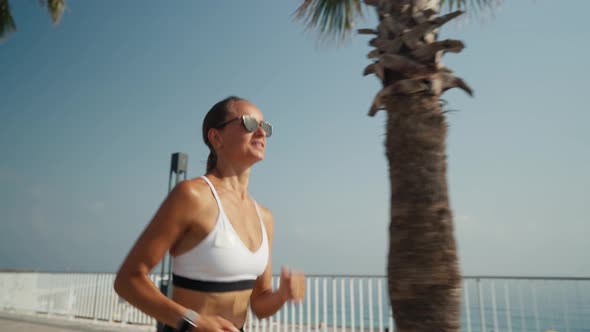 Outdoor Shot of Fitness Young Woman Jogging Along the Beach