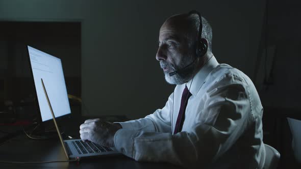 Man in Headset Using Laptop