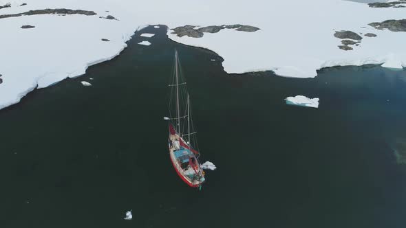 Yacht Sail in Arctic Iceberg Coast Aerial View