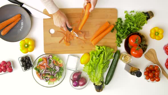 Hands Peeling Carrot with Vegetable Peeler