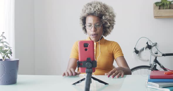 Latin American Woman with Afro Hair Doing a Live with a Smartphone