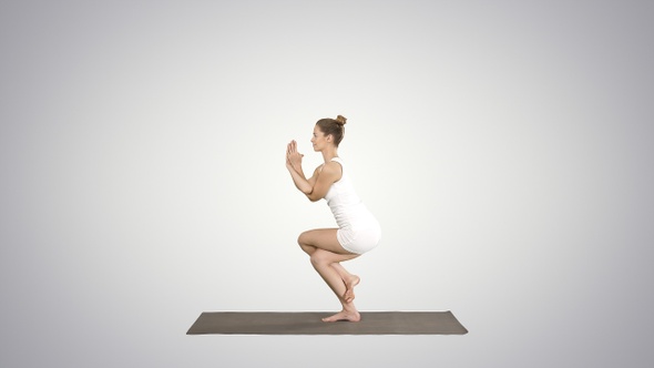 Beautiful young woman doing yoga exercise for ankles calves,