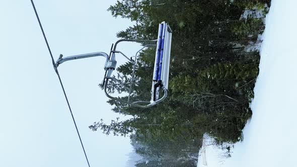 POV Empty Ski Lift Snowy Mountain Winter Forest with Chair Lift At The Ski Resort in Winter