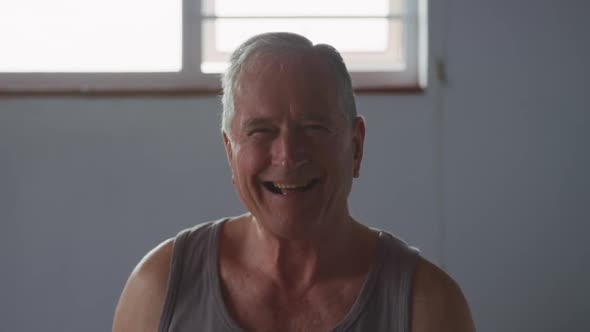 Senior man smiling at camera at home