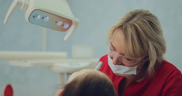 Beautiful Female Dentist Treats Patient Caries