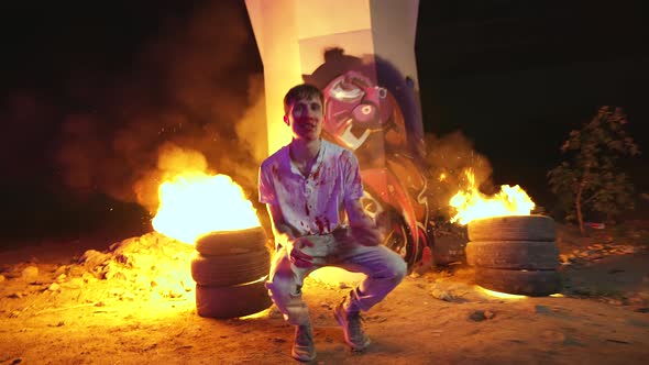 Rap Arstist in Clothes of Serial Killer Filming Music Video with Burning Fires