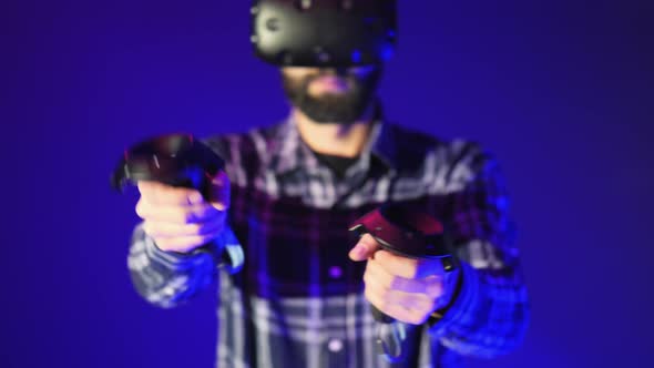 Close-up of Controllers From VR, Shoots in a Shooter Virtual Reality Game. Man Wearing VR Headset on