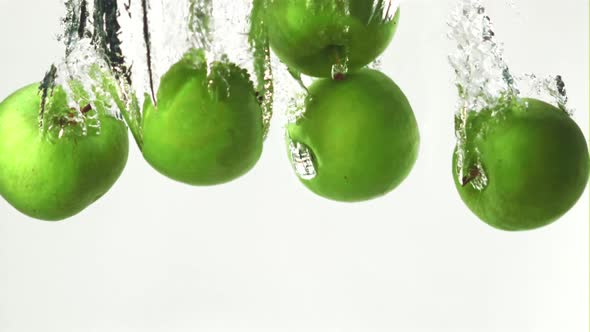 Super Slow Motion Whole Green Apples Fall Under the Water with Air Bubbles