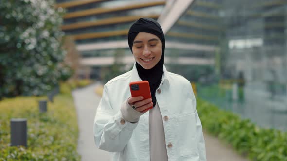 Arabian Woman Walking at Shopping Mall with Mobile in Hands
