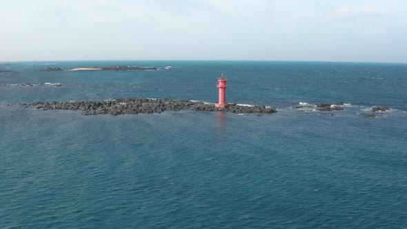 Aerial view. A lighthouse standing in the middle of the sea like an island. Dron