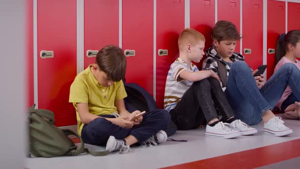 Tracking video of group of children using smartphone at school. Shot with RED helium camera in 8K.