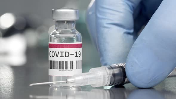 Coronavirus Covid-19 vaccine vial in medical lab with syringe