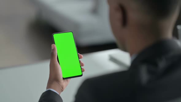 Rear View of African Businessman using Smartphone with Chroma Screen