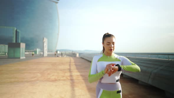 Sportswoman Using Smart Watch During Run