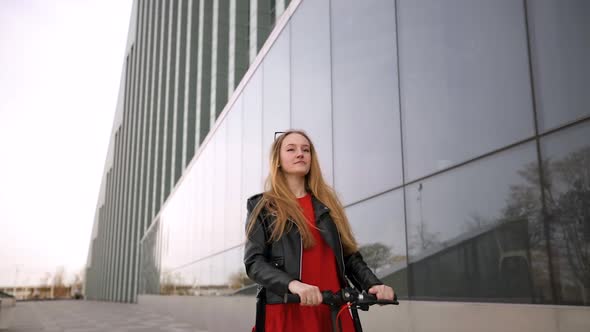 Young Woman Rides Electric Scooter