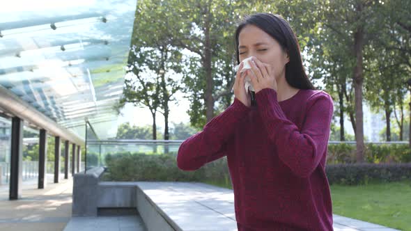 Woman sneeze at outdoor 