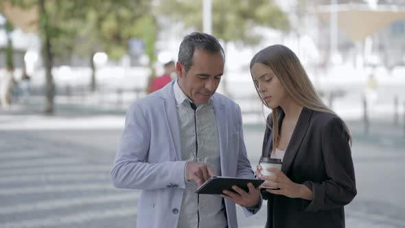 Happy Male and Female Colleagues Using Tablet Pc Outdoor