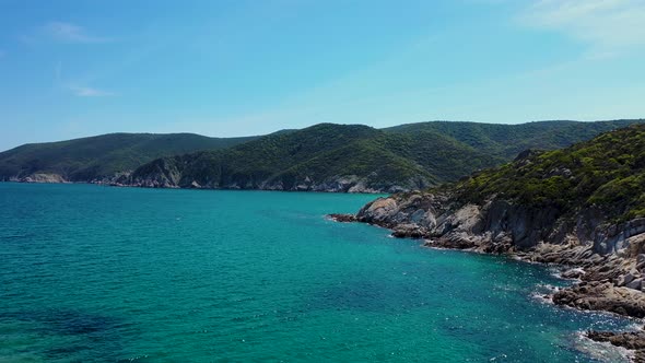 Hidden beach discovered behind rocky coastline and crystal clear blue sea in the Mediterranean aeria