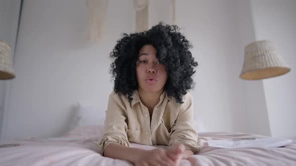 Angry Nervous African American Woman Gesturing Talking Looking at Camera Lying on Bed